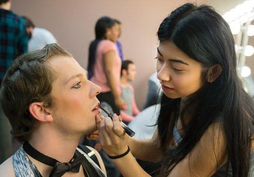  Theatre student Gabby Shaikh finishes stage makeup for fellow student and emcee Corbin George. Photo by Woody Myers